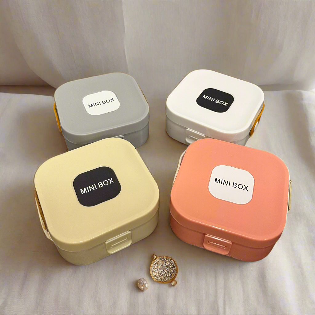 Four small storage boxes with 'MINI BOX' labels on a wooden surface.