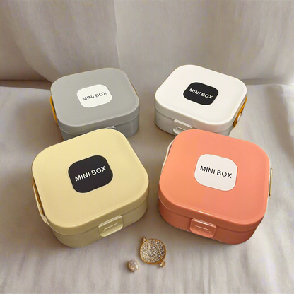 Four small storage boxes with 'MINI BOX' labels on a wooden surface.