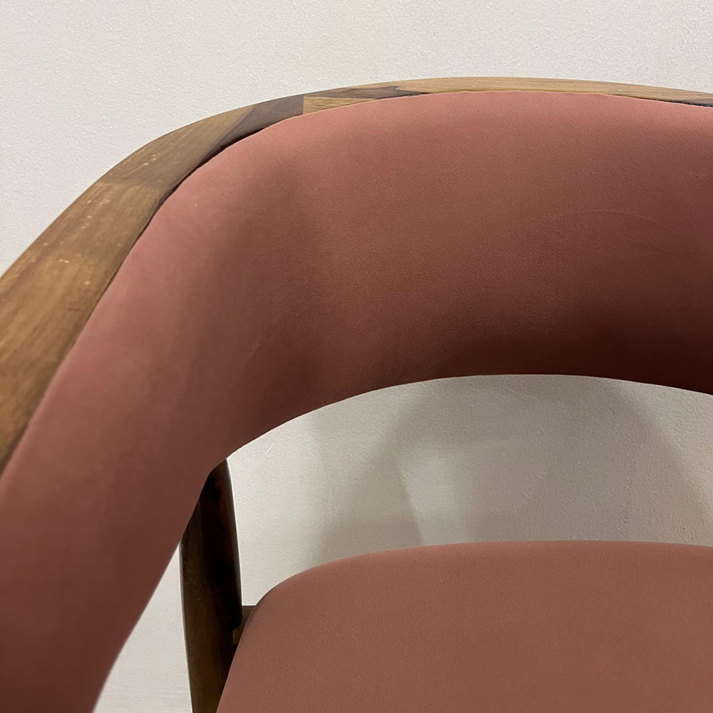 Close-up of a chair with a curved backrest and armrests on a plain background